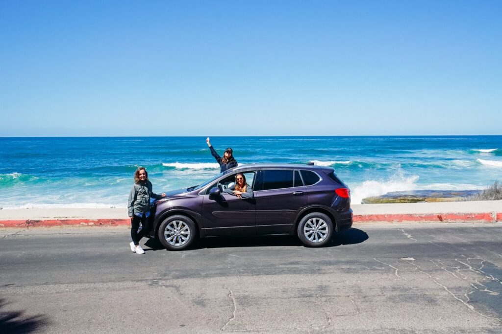 foto de amigas em carro de frente ao mar no sul da Califórnia